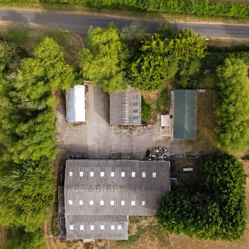 Overhead shot of four different barns, all with different coloured roofs